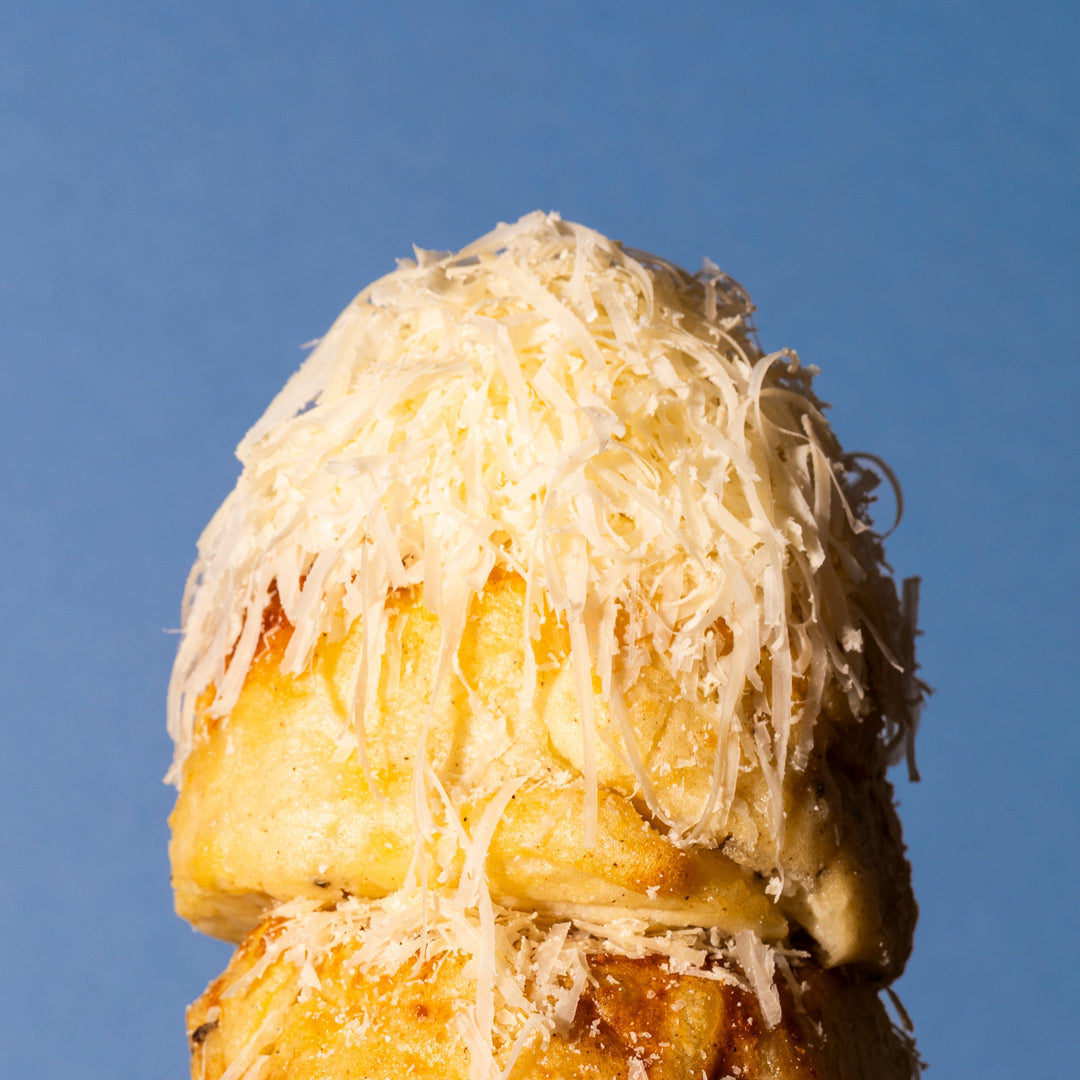 Stack of cheesy gratins on a plate against a blue background